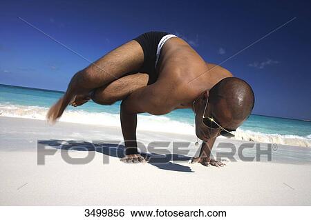 Man standing on his hands on a beach, low angle view View Large Photo Image Stock Photograph - Man standing on his hands on a beach, low angle view . Fotosearch