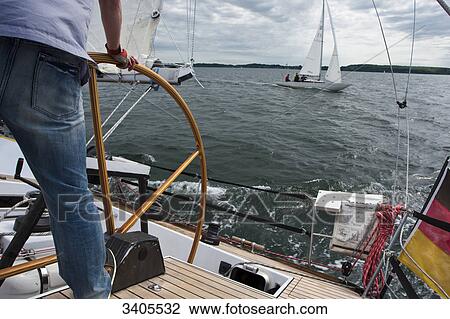 Man steering a yacht on a sailing trip between Flensburg and Sonderburg on the Baltlc Sea View Large Photo Image Stock Image - Man steering a yacht on a sailing trip between Flensburg and Sonderburg on the Baltlc Sea . Fotosearch