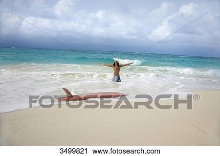 Man with surfboard on the beach, Paradise Island, Bahamas View Large Photo Image Stock Image - Man with surfboard on the beach, Paradise Island, Bahamas . Fotosearch