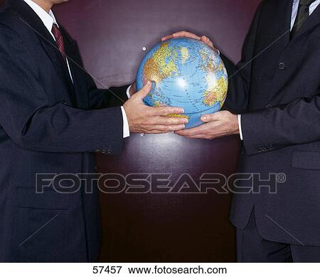 Mid section view of two businessmen holding globe View Large Photo Image Stock Photo - Mid section view of two businessmen holding globe . Fotosearch