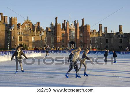 Stock Image - People ice-skating in front of palace, Hampton Court Palace, Hampton, London, England . Fotosearch