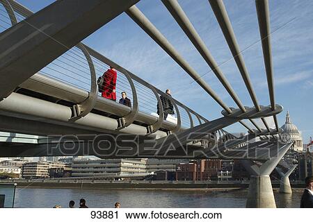 Stock Image - People walking on footbridge with cathedral in background, St. Paul's Cathedral, London, England . Fotosearch