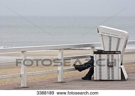 Person sitting in Hooded Beach Chair on waterside promenade, Westerland, Sylt, Germany View Large Photo Image Stock Photo - Person sitting in Hooded Beach Chair on waterside promenade, Westerland, Sylt, Germany . Fotosearch