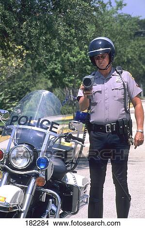 Policeman standing near motorcycle View Large Photo Image Picture - Policeman standing near motorcycle . Fotosearch