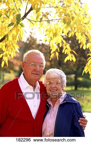 Stock Photograph - Portrait of senior couple smiling in park . Fotosearch