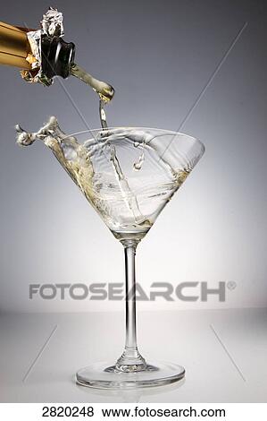 Stock Photo - pouring champagne into a glass, close-up . Fotosearch