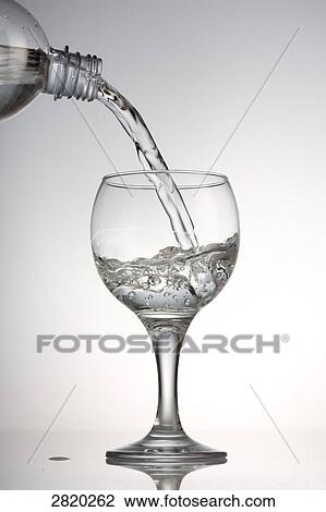 Stock Image - pouring in of water into a glass, close-up . Fotosearch