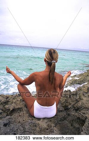 Rear view of woman practicing yoga at coast View Large Photo Image Stock Image - Rear view of woman practicing yoga at coast . Fotosearch
