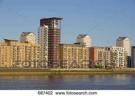 Stock Image - Residential buildings at waterfront, Thames River, Canary Wharf, Tower Hamlets, London, England . Fotosearch