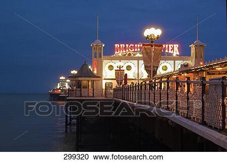 Stock Image - Resort at coast lit up at night, Brighton, Sussex, England . Fotosearch
