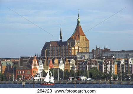 Sailboat in river in front of town, Mecklenburg-West Pomerania, Germany View Large Photo Image Stock Image - Sailboat in river in front of town, Mecklenburg-West Pomerania, Germany . Fotosearch