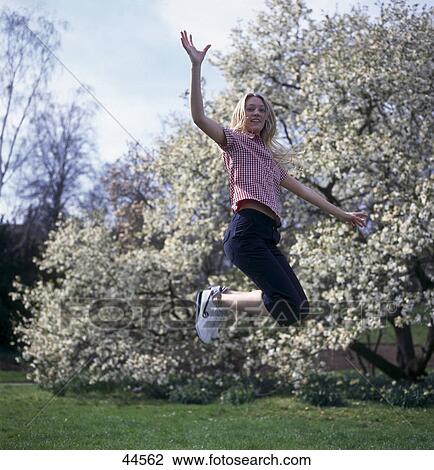 Side profile of young woman jumping in park View Large Photo Image Stock Image - Side profile of young woman jumping in park . Fotosearch
