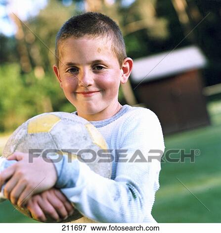 Smiling boy holding ball View Large Photo Image Stock Photo - Smiling boy holding ball . Fotosearch