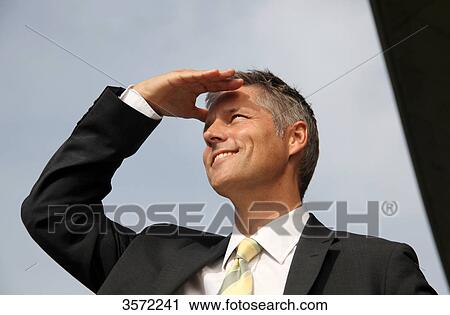 Smiling businessman outdoors looking around View Large Photo Image Stock Image - Smiling businessman outdoors looking around . Fotosearch