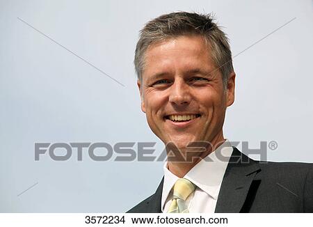 Smiling businessman outdoors, portrait View Large Photo Image Picture - Smiling businessman outdoors, portrait . Fotosearch