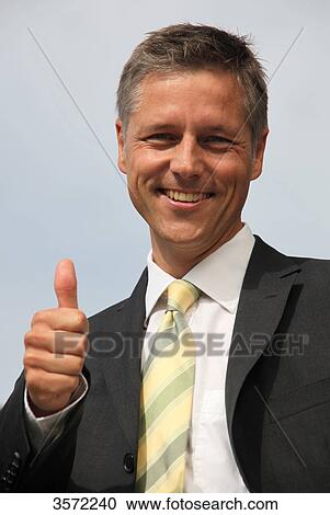 Smiling businessman with thumb up, portrait View Large Photo Image Stock Image - Smiling businessman with thumb up, portrait . Fotosearch