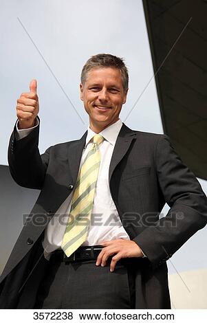 Stock Photo - Smiling businessman with thumb up . Fotosearch