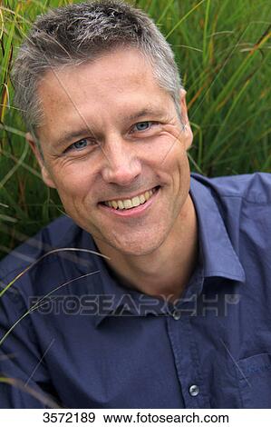 Smiling man outdoors, portrait View Large Photo Image Stock Photo - Smiling man outdoors, portrait . Fotosearch