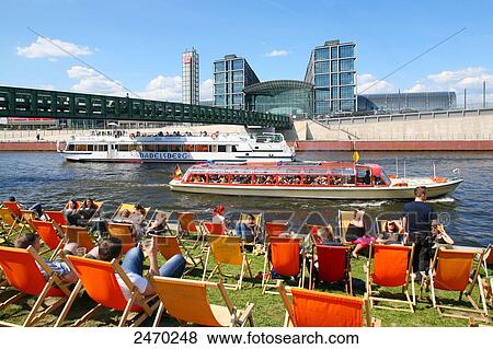 Tourist relaxing on deck chairs near river, Germany View Large Photo Image Stock Photo - Tourist relaxing on deck chairs near river, Germany . Fotosearch