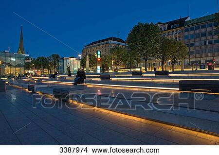 Picture - Tourists sitting on lit-up benches at the Jungfernstieg, Hamburg, Germany . Fotosearch