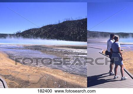 Tourists standing on boardwalk looking at hot spring, Yellowstone National Park, Wyoming, USA View Large Photo Image Stock Image - Tourists standing on boardwalk looking at hot spring, Yellowstone National Park, Wyoming, USA . Fotosearch