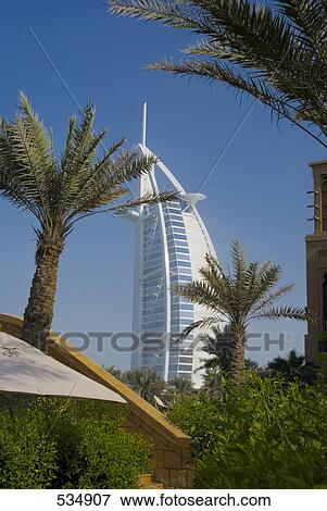 Stock Photo - Trees with hotel in background, Burj Al Arab Hotel, Dubai, United Arab Emirates . Fotosearch