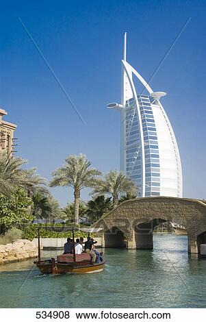 Turistas En Barco Con Hotel En Plano De Fondo Burj Al Arabe Hotel Dubai Emiratos Arabes Unidos Coleccion De Foto Fotosearch