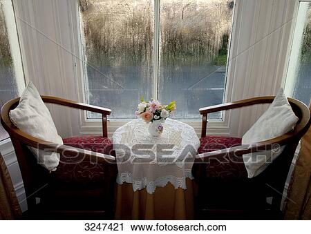 Two chairs and a desk with flowers View Large Photo Image Stock Image - Two chairs and a desk with flowers . Fotosearch