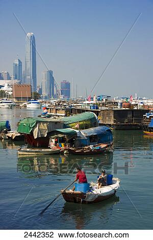 Stock Image - Two people on sampan in sea, Hong Kong, China . Fotosearch
