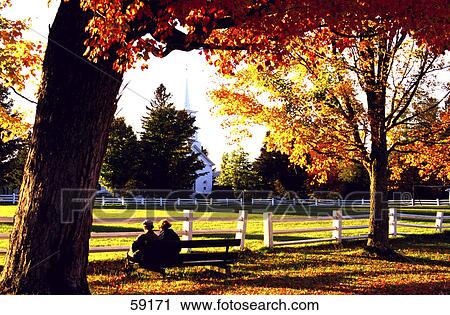 Stock Image - Two people sitting on bench, Vermont, USA . Fotosearch