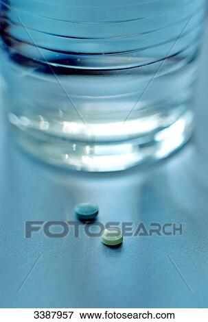 Two pills and water glass, close-up View Large Photo Image Stock Photo - Two pills and water glass, close-up . Fotosearch