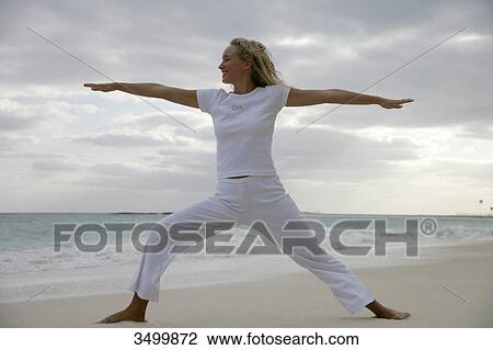 Woman doing yoga on a beach, low angle view View Large Photo Image Stock Image - Woman doing yoga on a beach, low angle view . Fotosearch