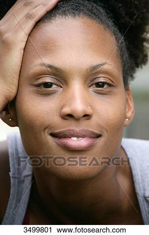 Stock Image - Woman leaning head against her hand, portrait . Fotosearch