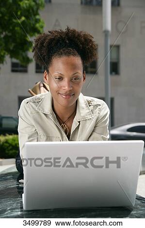 Stock Photo - Woman lying in front of a notebook . Fotosearch