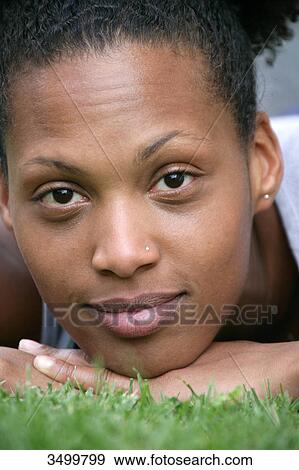 Woman lying on a lawn, portrait View Large Photo Image Stock Photo - Woman lying on a lawn, portrait . Fotosearch