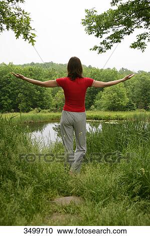 Woman meditating by a pond, rear view View Large Photo Image Stock Image - Woman meditating by a pond, rear view . Fotosearch
