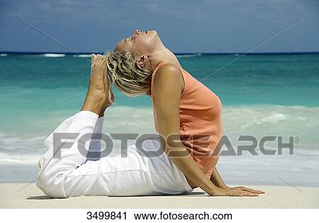 Woman practising yoga on a beach, Paradise Island, Bahamas, side view View Large Photo Image Stock Image - Woman practising yoga on a beach, Paradise Island, Bahamas, side view . Fotosearch