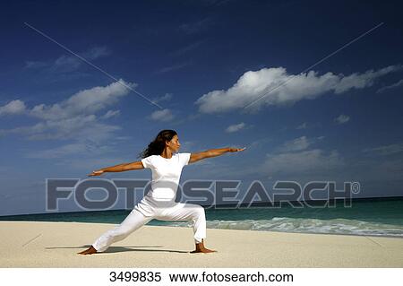 Stock Photography - Woman practising yoga on a beach, Paradise Island, Bahamas, side view . Fotosearch