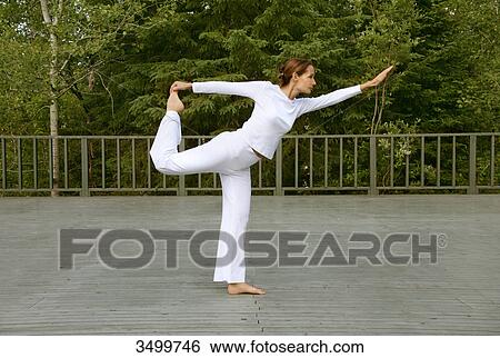 Woman practising yoga on a deck, side view View Large Photo Image Stock Photograph - Woman practising yoga on a deck, side view . Fotosearch