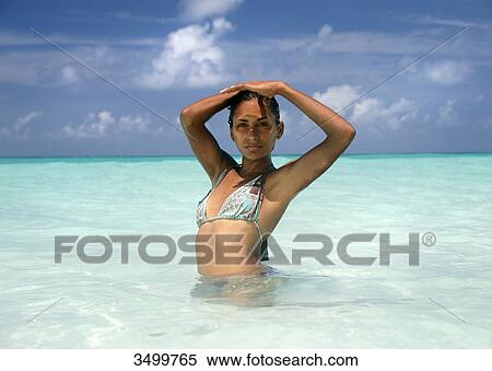 Woman standing in the water and shading eyes with her hands View Large Photo Image Stock Photography - Woman standing in the water and shading eyes with her hands . Fotosearch