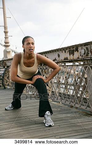 Picture - Woman standing on Brooklyn Bridge and stretching, New York City, USA, low angle view . Fotosearch