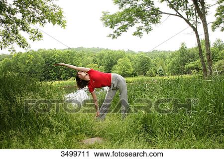 Woman stretching by a pond, front view View Large Photo Image Stock Image - Woman stretching by a pond, front view . Fotosearch