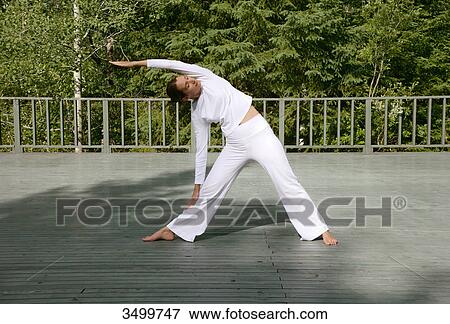 Stock Photo - Woman stretching on a deck, front view . Fotosearch