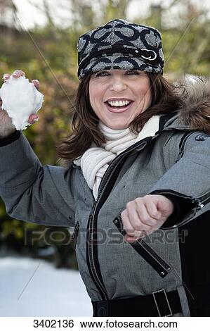 Woman throwing snowball View Large Photo Image Stock Photograph - Woman throwing snowball . Fotosearch