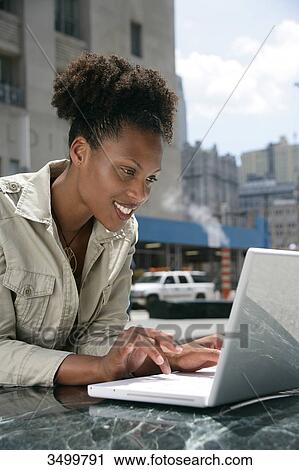 Woman using a notebook View Large Photo Image Stock Image - Woman using a notebook . Fotosearch