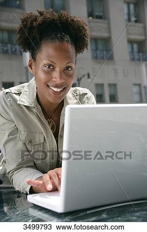 Woman with a notebook smiling at camera View Large Photo Image Stock Image - Woman with a notebook smiling at camera . Fotosearch