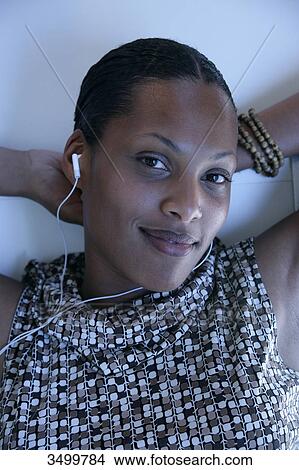 Woman with earphones smiling at camera View Large Photo Image Picture - Woman with earphones smiling at camera . Fotosearch