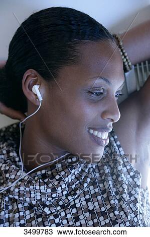 Stock Image - Woman with earphones smiling into camera . Fotosearch