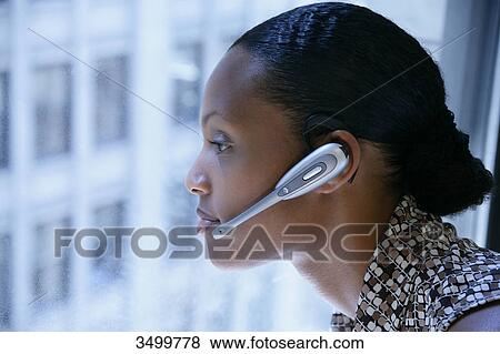 Stock Photo - Woman with headset looking out of a window, profile . Fotosearch