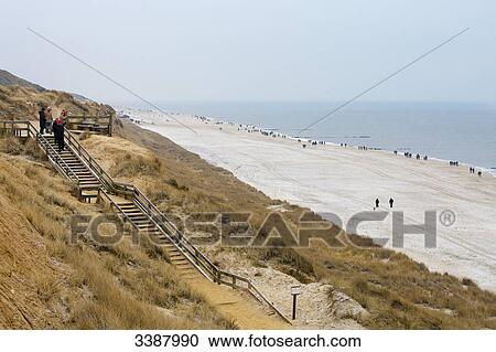 Stock Image - Wooden staircase on dunes at the North sea coast, Kampen, Sylt, Germany, elevated view . Fotosearch